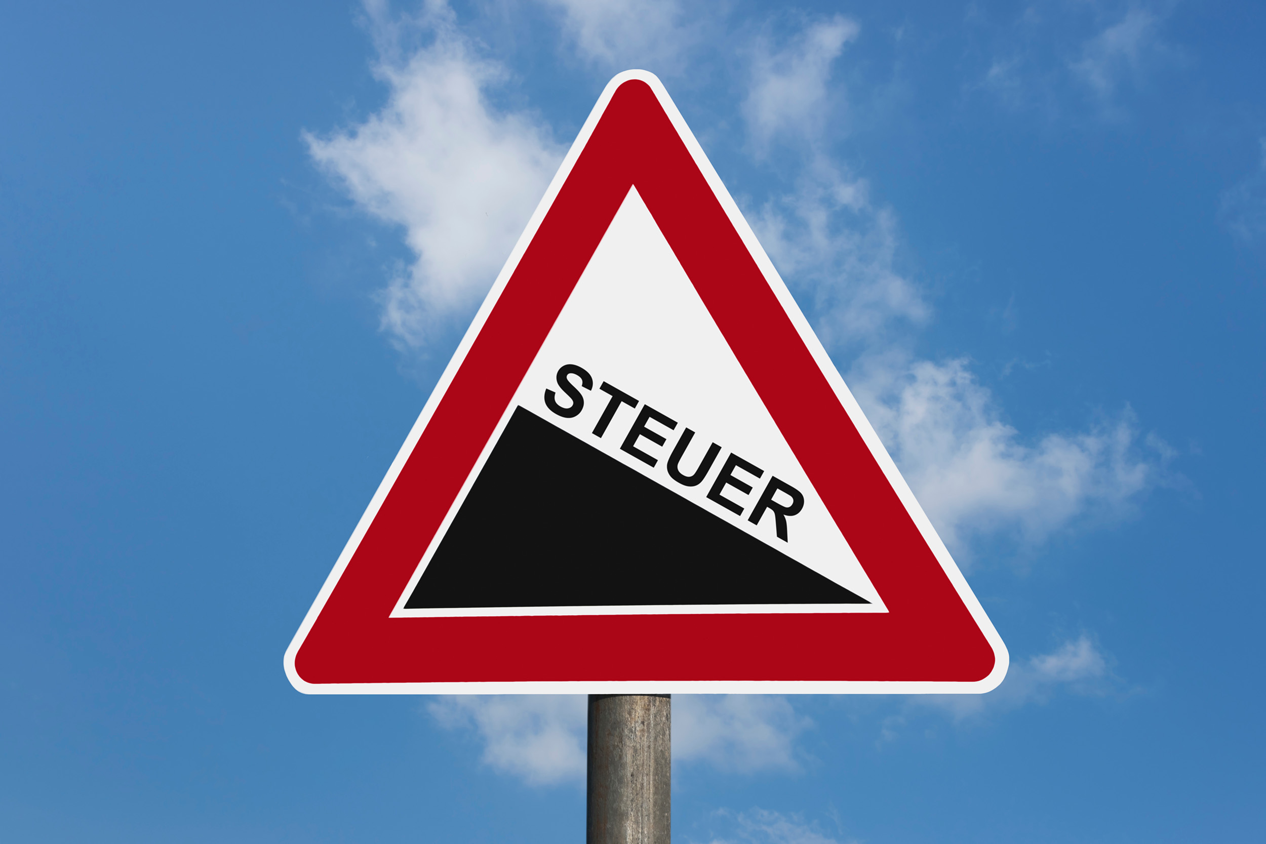 Dreieckiges Warnschild mit rotem Rand und der Aufschrift „STEUER“, das vor einer steilen Neigung warnt, vor blauem Himmel mit Wolken.