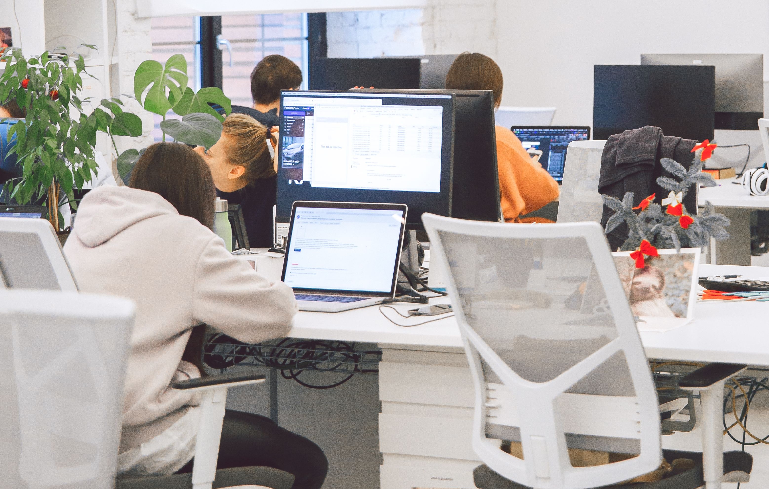 Moderner Arbeitsplatz, mit vier Leuten, die vor Bildschirmen arbeiten