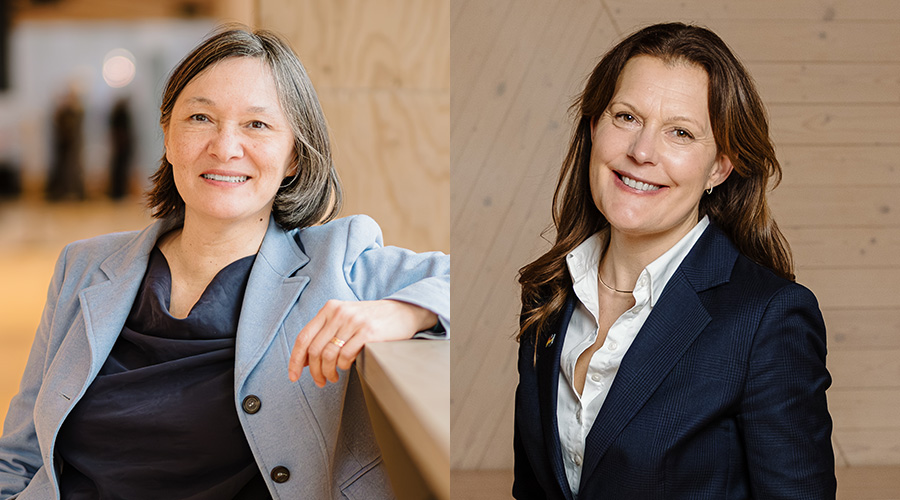 Två personer i professionella outfits står framför en ljus trävägg, fotograferade i porträttstil.