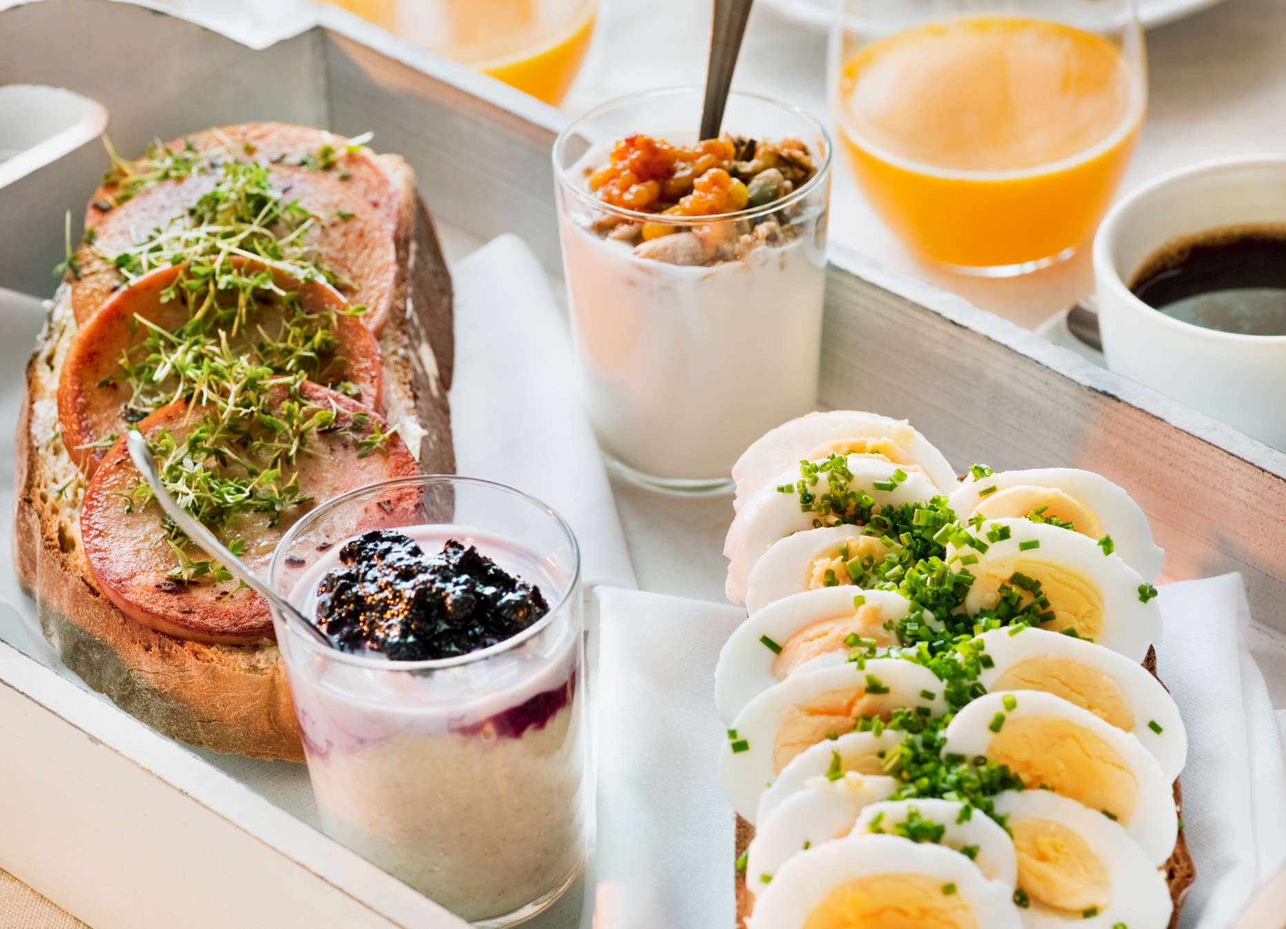 Falukorv auf geröstetem Brot mit frischen Kräutern, serviert als Teil eines schwedischen Frühstücks.