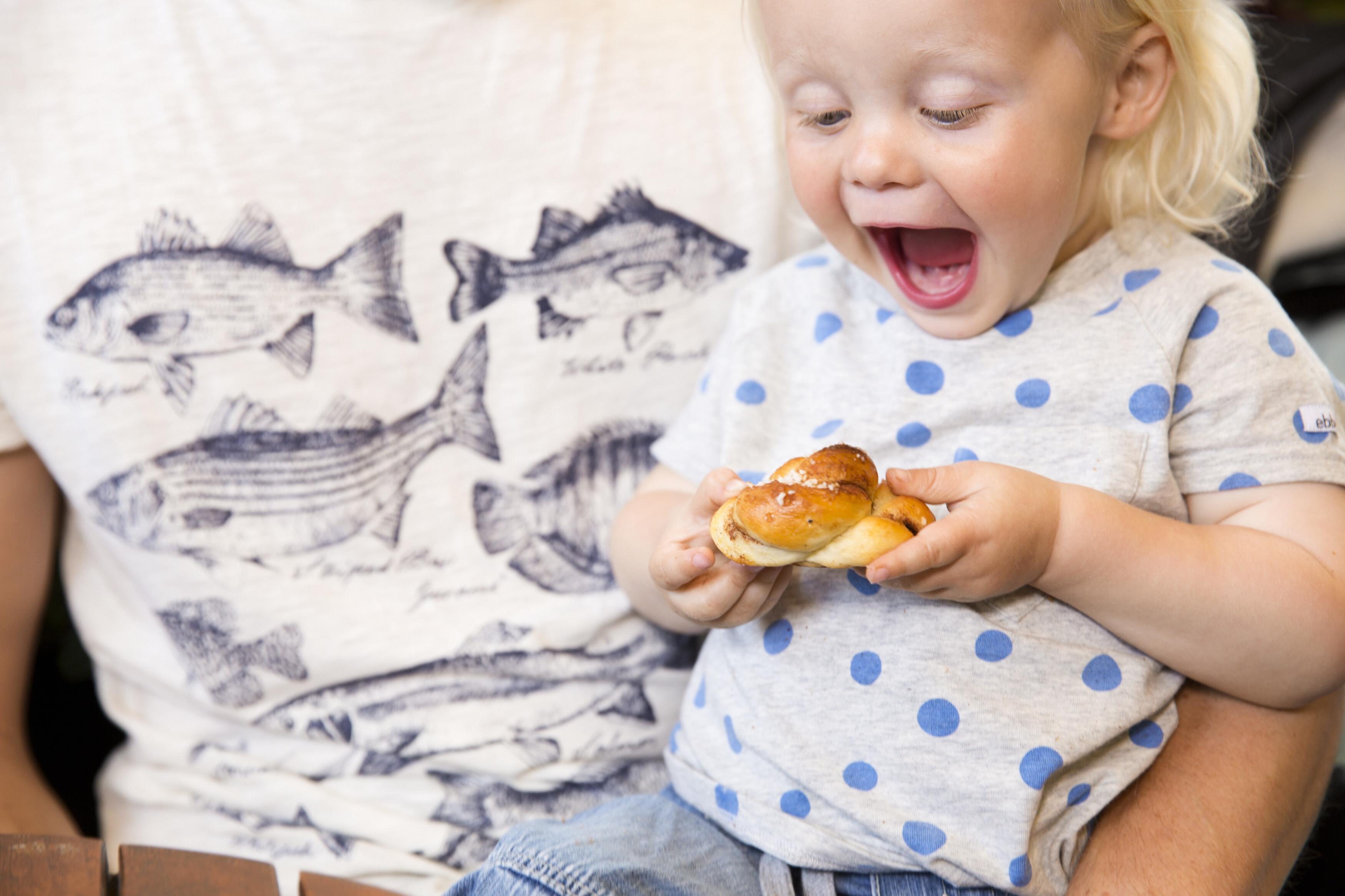 Kanelbulle, schwedisches Zimtschneckengebäck, in den Händen eines Kindes.