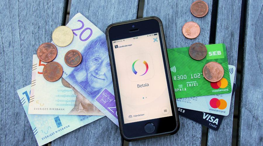 Bargeld, ein Smartphone mit der Swish-App sowie mehrere Kreditkarten