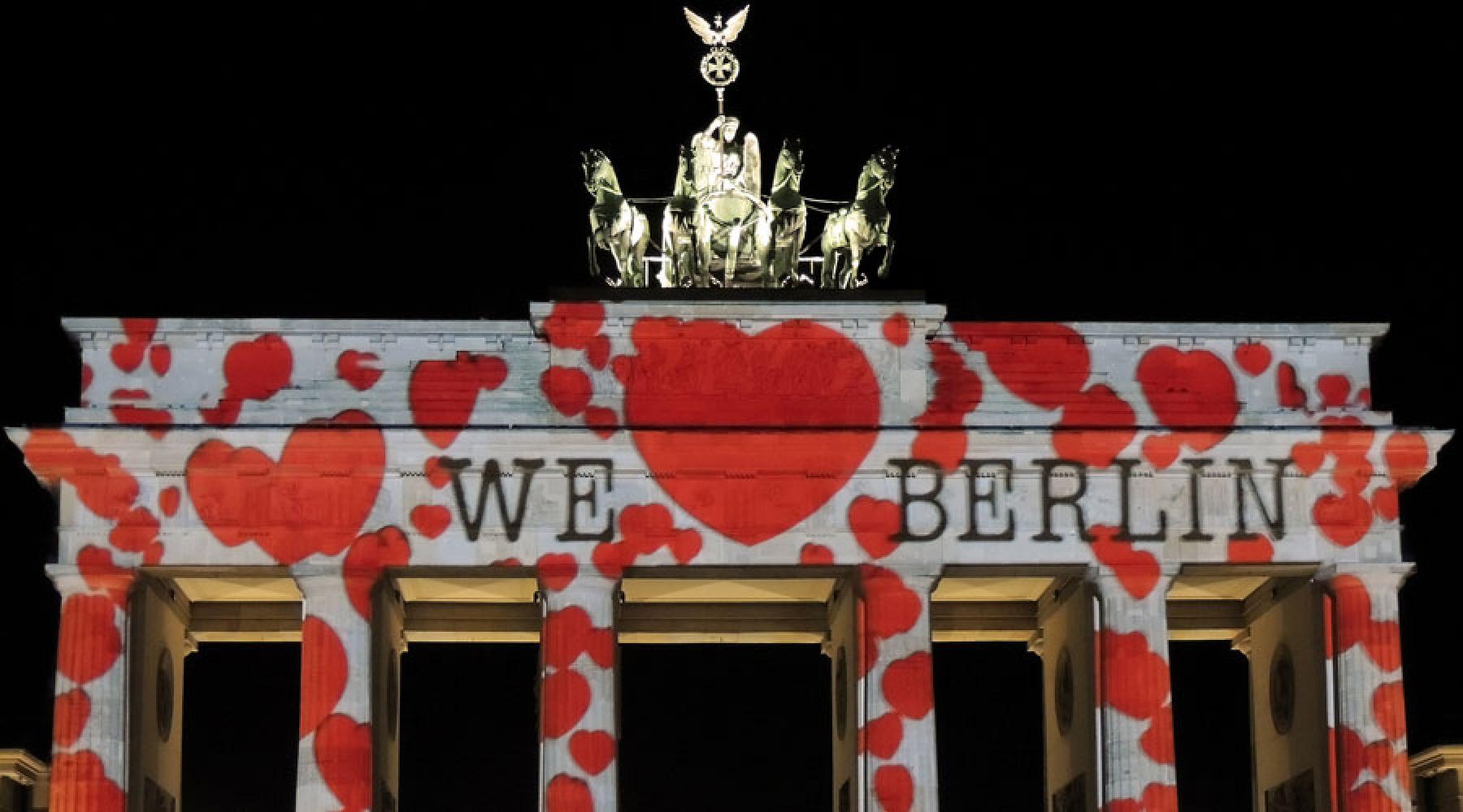 En ljusinstallation direkt på Brandenburger Tor i Berlin: många hjärtan och texten We love Berlin