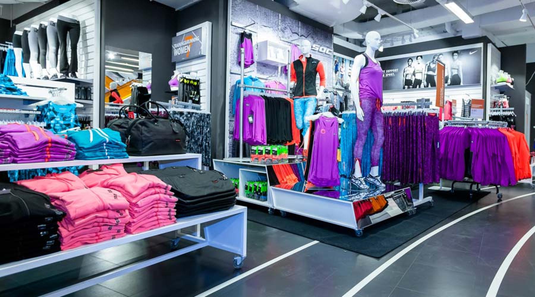En Stadiumbutik: olika träningskläder på hyllor och klädställ