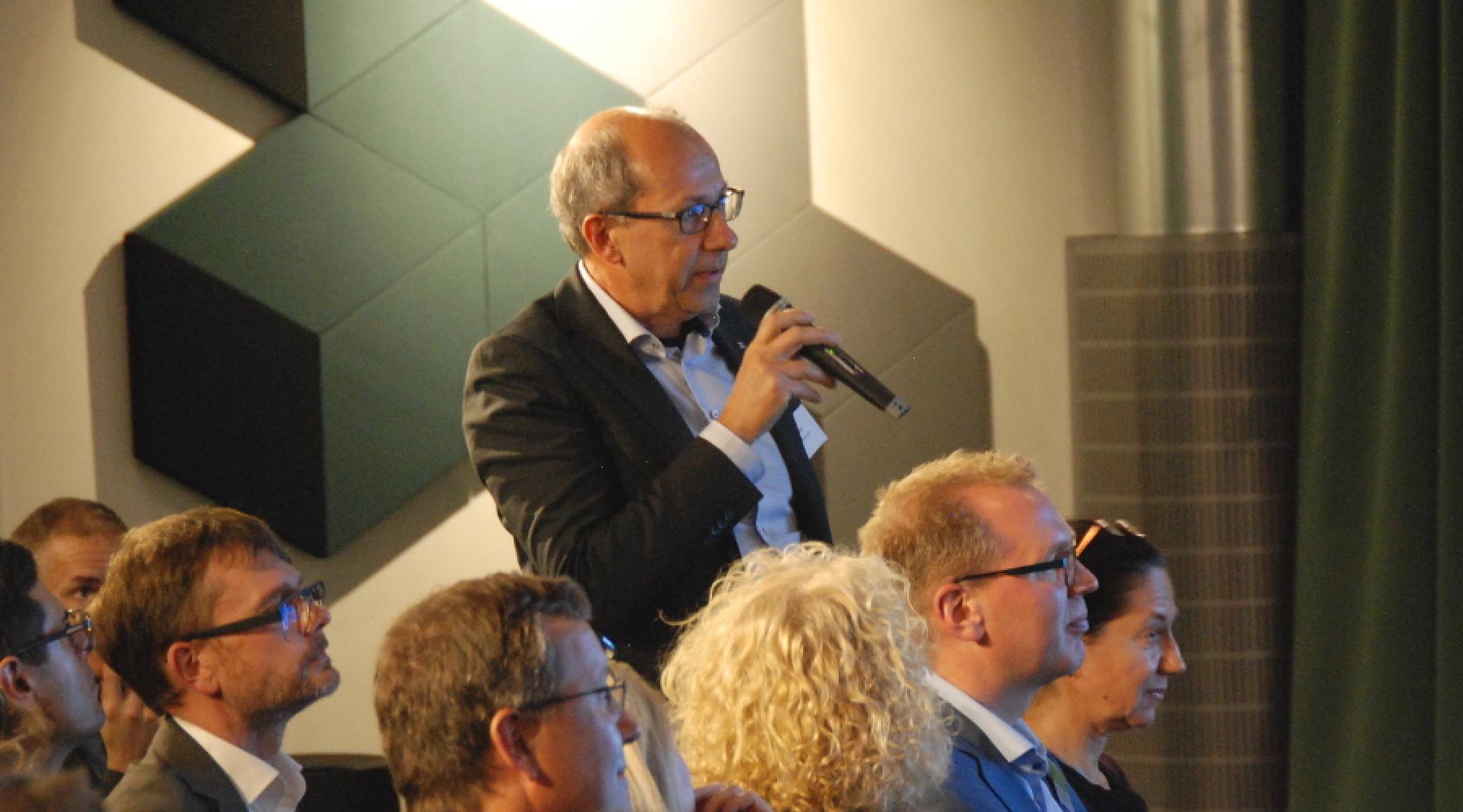 En man ställer en publikfråga under seminariet om hållbarhet och innovation på Epicenter i Stockholm.