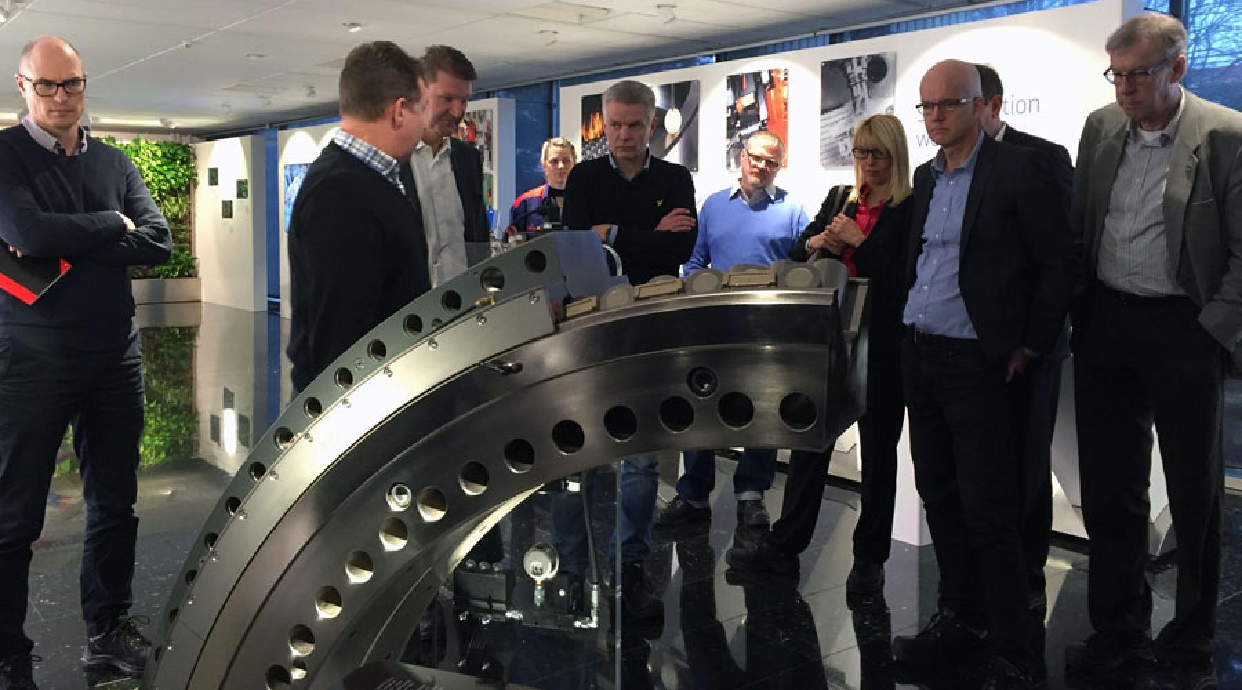Eine Besuchergruppe steht um ein Wälzlagermodell in SKFs Fabrik in Göteborg