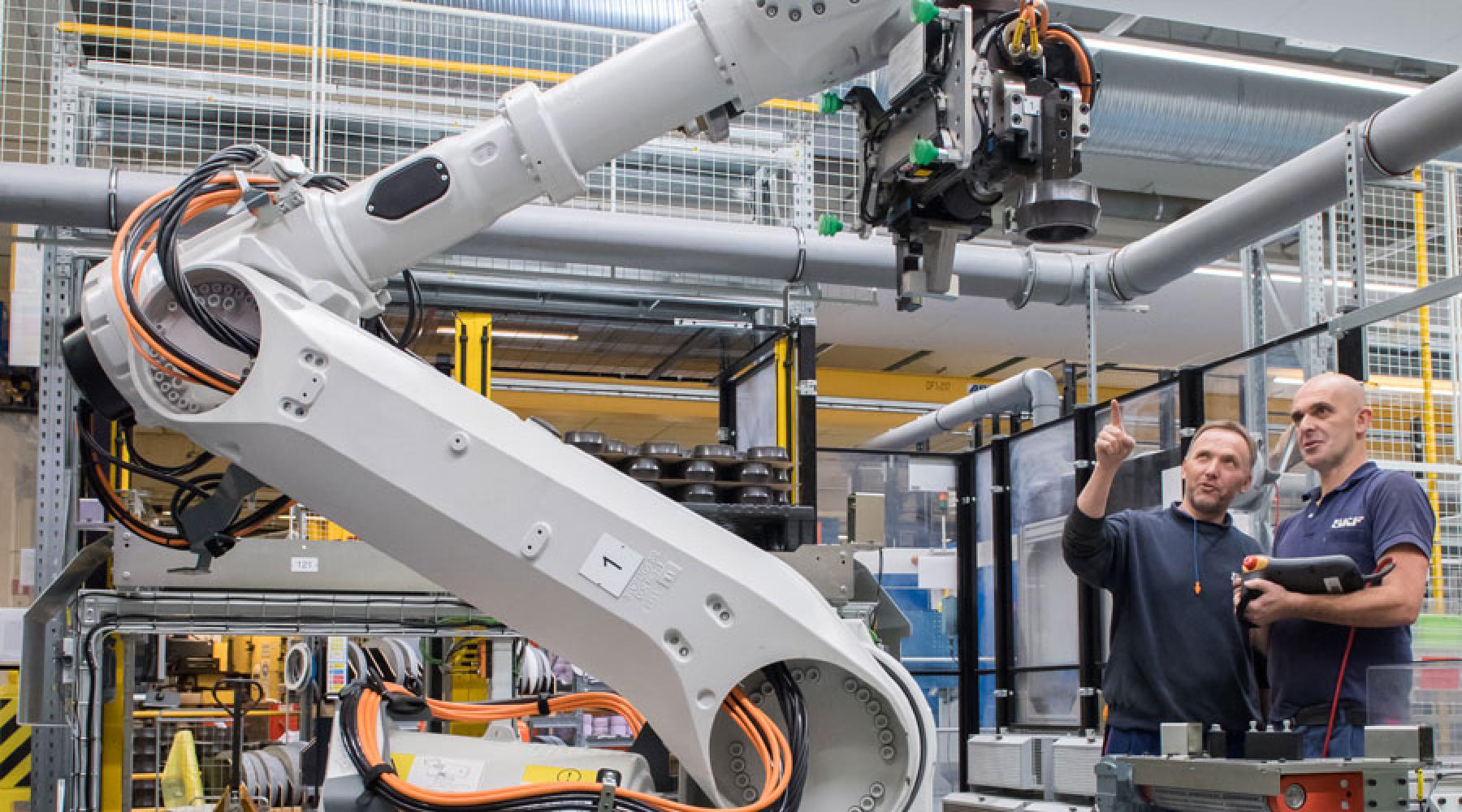 Zwei SKF-Mitarbeiter bedienen eine Roboterzelle in der neuen und vollständig automatisierten Fabrik