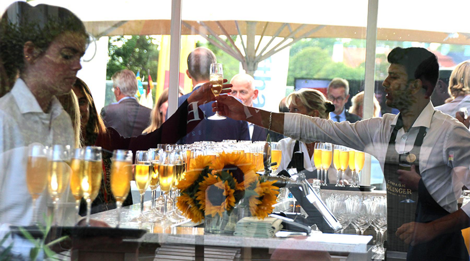 En bartender räcker över ett glas på Tysk-Svenska Handelskammarens business kickoff 2018