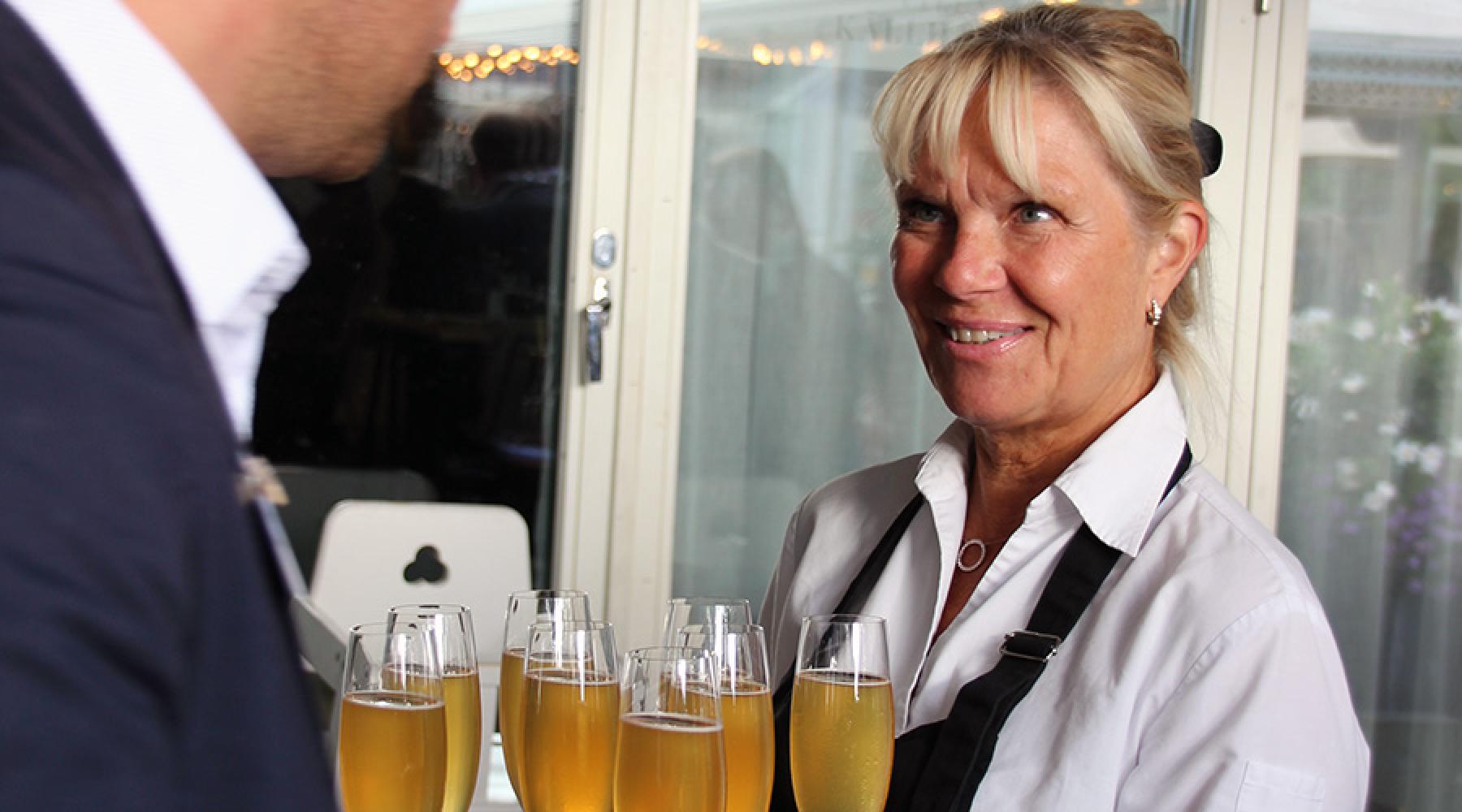 En servitör delar ut välkomstdrinkar på Tysk-Svenska Handelskammarens business kickoff 2018