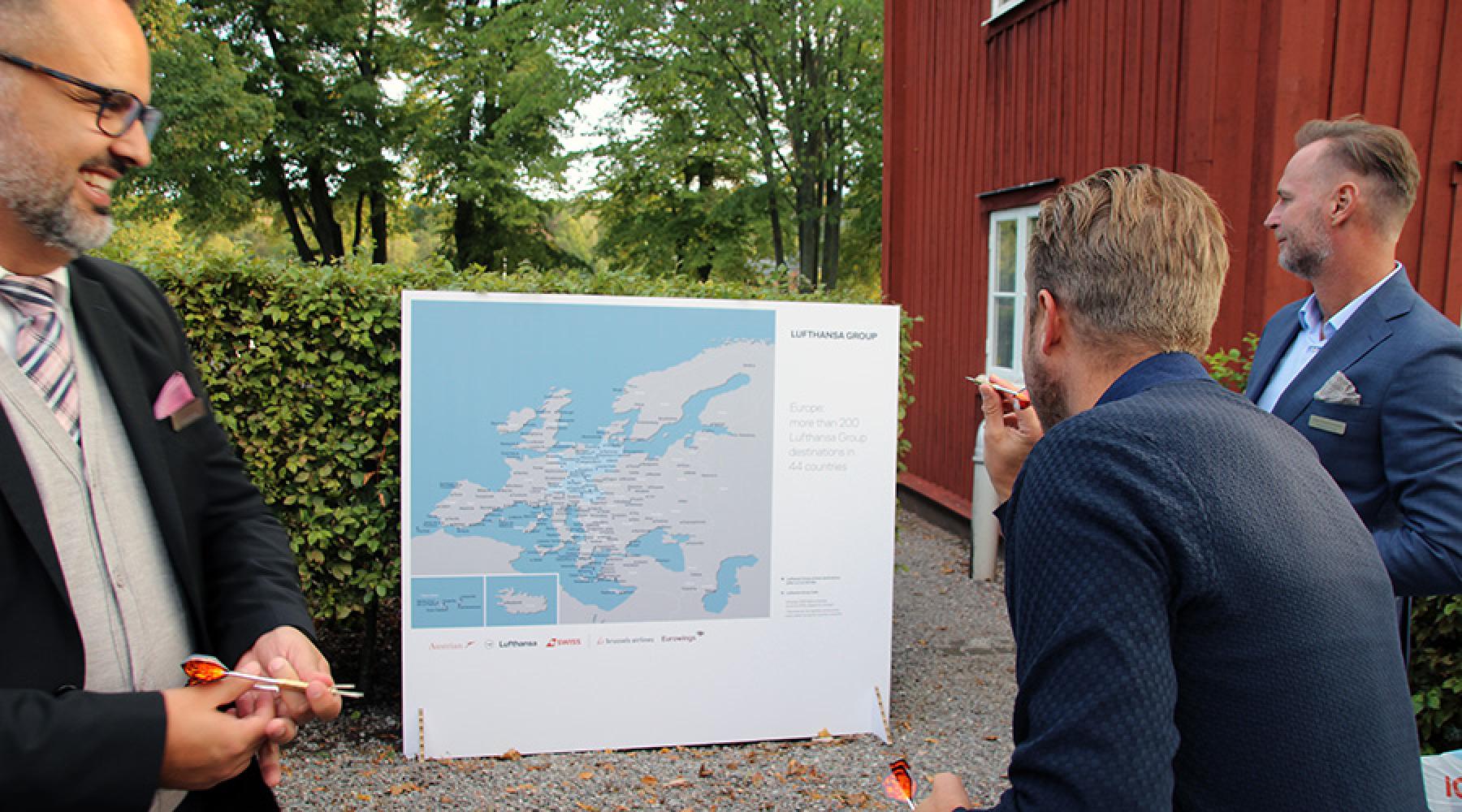 Besucher werfen Dartpfeile auf eine Europakarte auf dem Business Kick-off der Deutsch-Schwedischen Handelskammer 2018