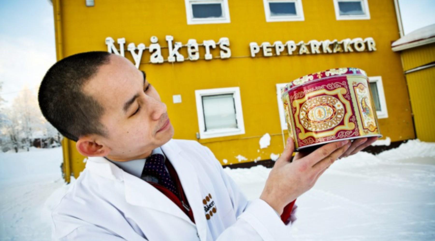 Nyåkers Pepparkakors vd Christoffer Öberg med en plåtburk i handen framför fabriken i Nyåker