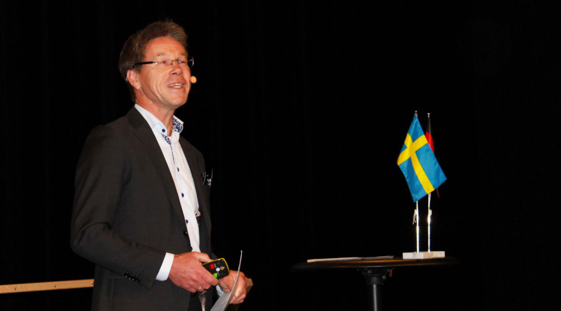 Karsten Keller, Vorstandsmitglied der Deutsch-Schwedischen Handelskammer, mit einer Schwedenflagge bei einem Studienbesuch der Deutsch-Schwedischen Handelskammer