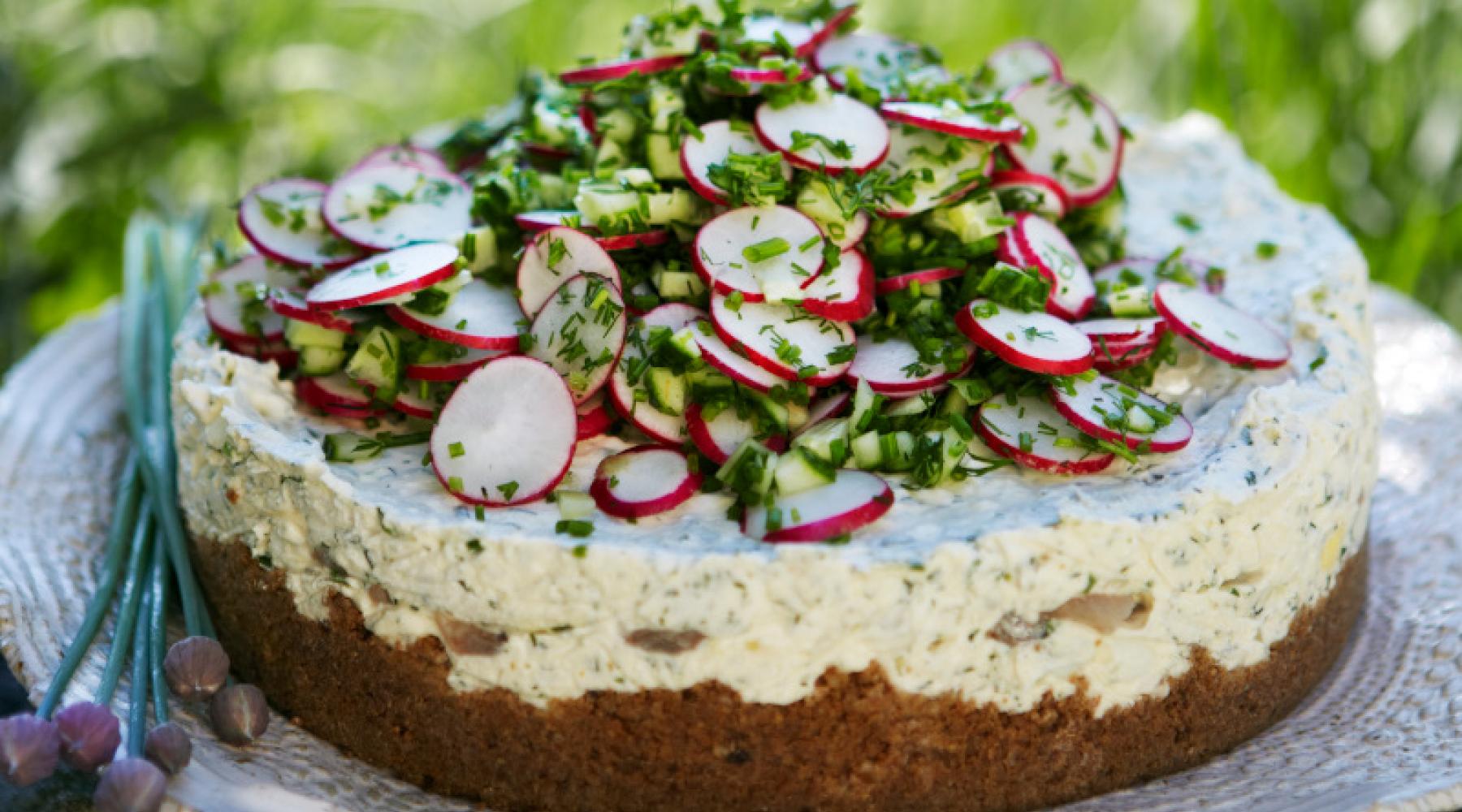 Eine klassische schwedische Smörgåstårta - Butterbrottorte - vor grünem Gras.