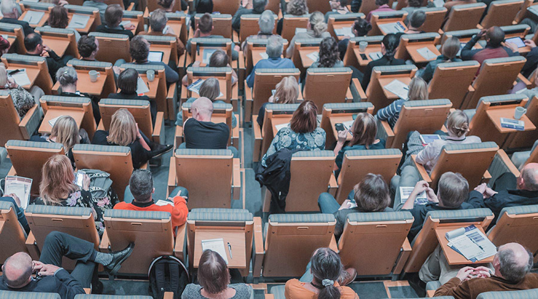 Åhörare i sina säten i en stor konferenslokal