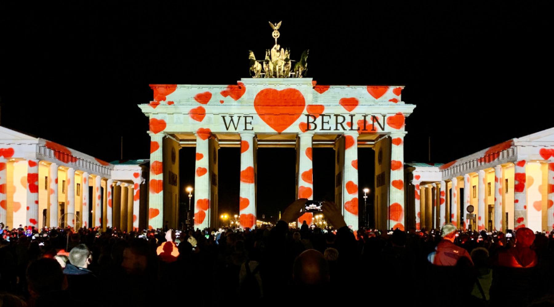 Brandenburger Tor i Berlin under en ljusfestival när texten "We <3 Berlin" syns över hela byggnaden.
