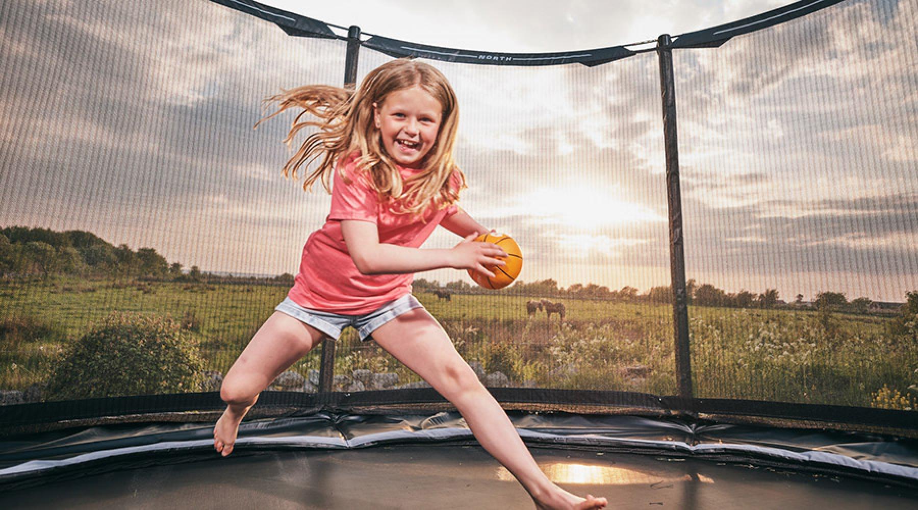 Glad flicka på en studsmatta från North Trampoline