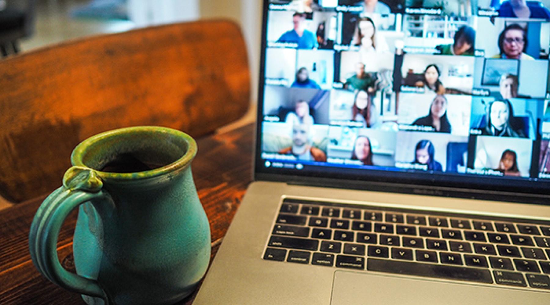 En mugg och en dator som visar en pågående videokonferens