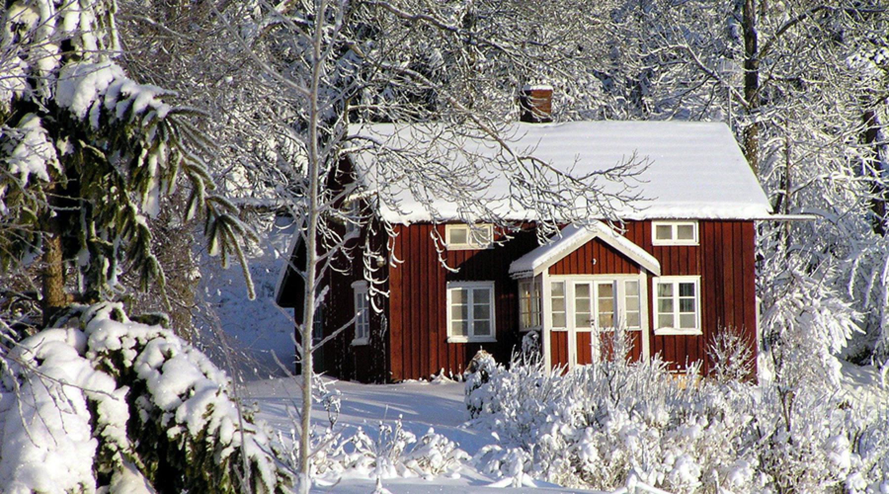 En röd stuga I ett vinterlandskap