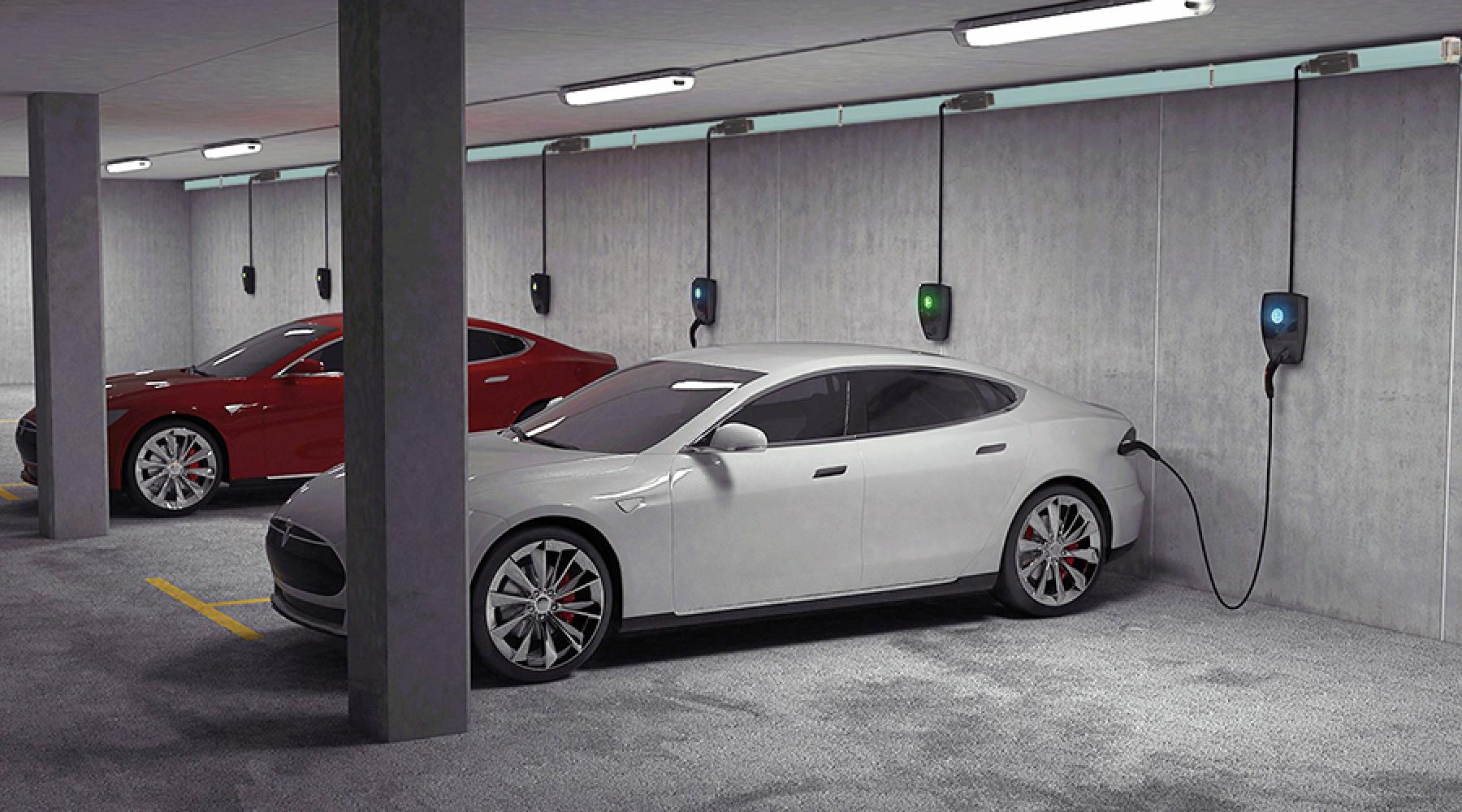 Bilden visar två bilar som laddas i ett garage.