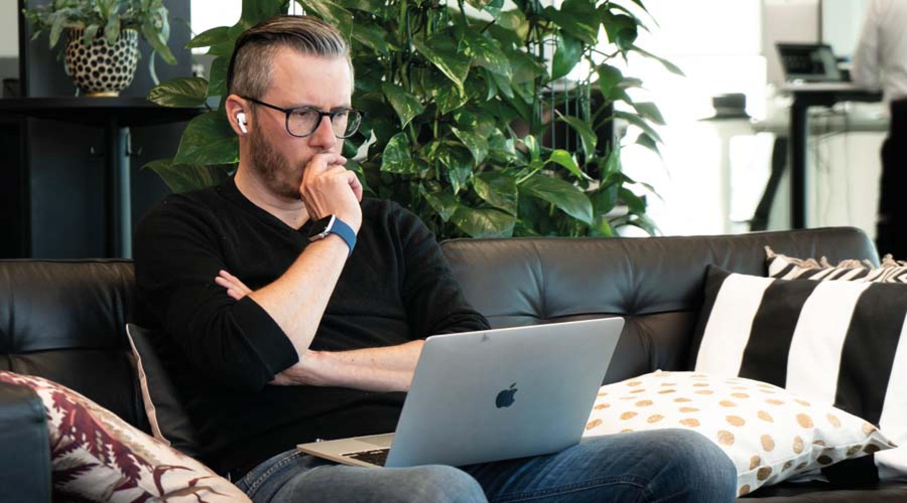 Bild: Junglemap Ein Mann mit einem Computer auf dem Schoss auf einer Couch