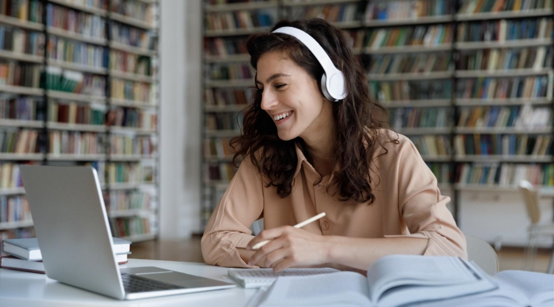 Kvinna med hörlurar som deltar i ett webinar